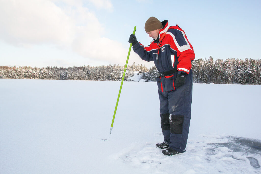 En man som testar isens hållbarhet med en ispik